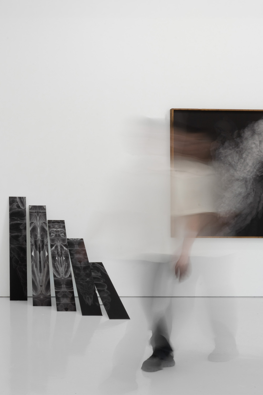 Visitor walking past artworks in a gallery